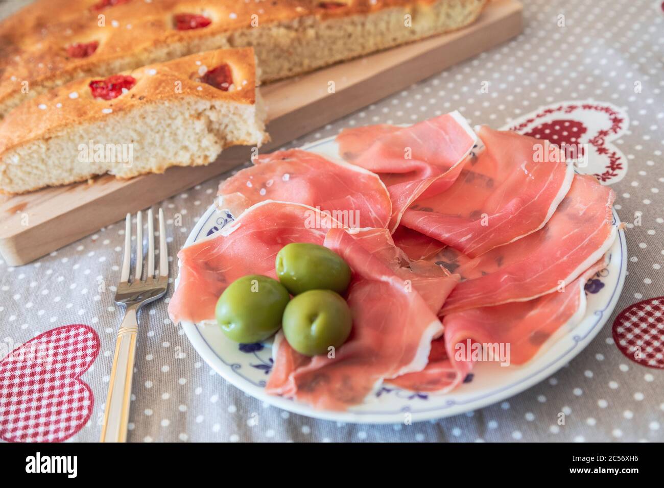 Hausgemachte Apulische Focaccia serviert mit Parmas Schinken und Oliven, typisch italienische Küche Stockfoto