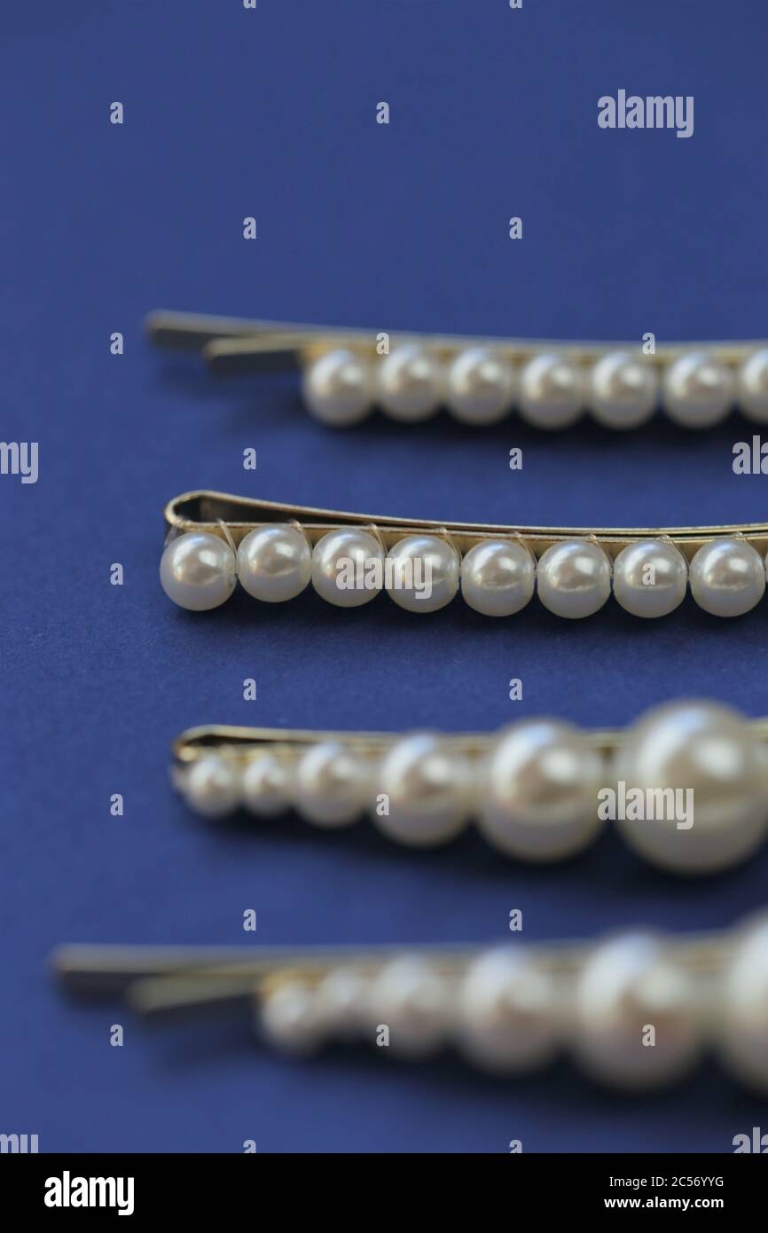 perlhaarclips auf einem hellblauen Hintergrund. Modische Haaraccessoires. Haarnadel mit Perlen.verschiedene Haarnadel Zubehör Set. Perlhaar Stockfoto