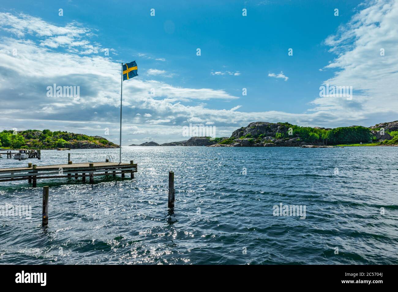 Landungssteg mit Flagge an der Küste bei Fjällbacka, Schweden Stockfoto