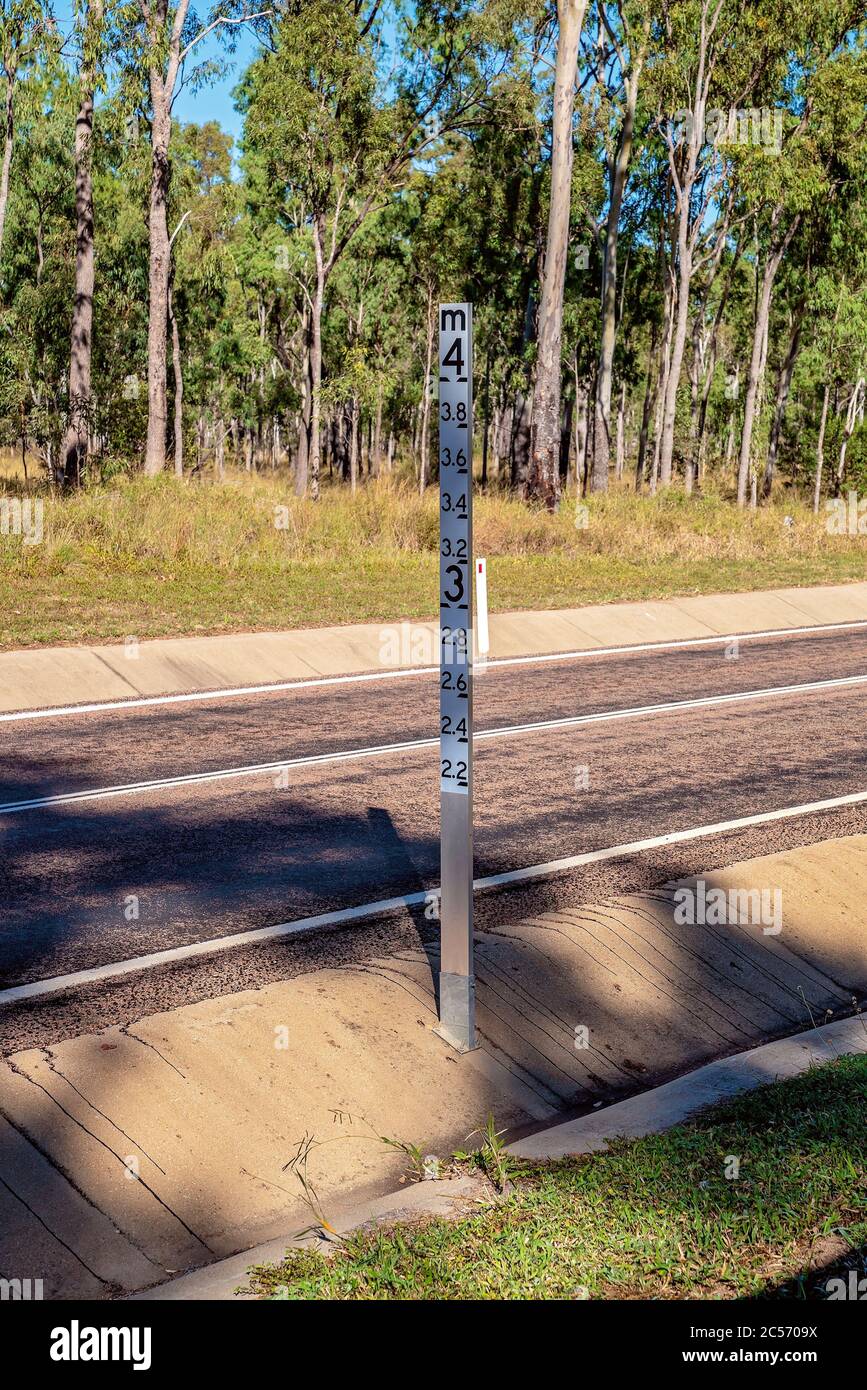Hochwassertiefe Schild auf niedrig liegendem Teil der Binnenautobahn in der Nähe eines Baches in Australien Stockfoto