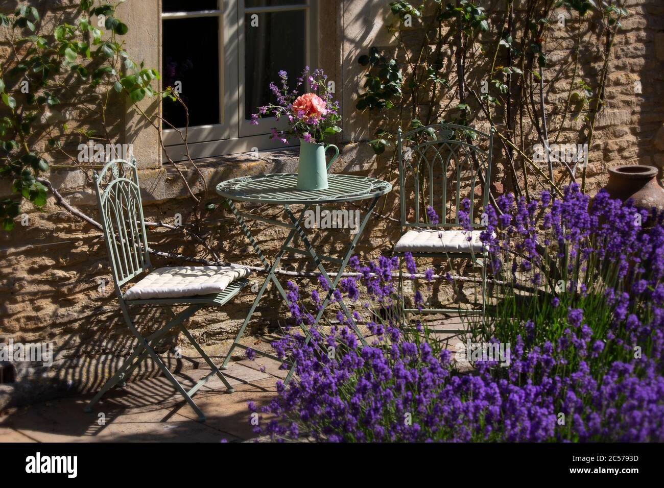 Metalltisch und Stühle im englischen Cottage Garden Stockfoto