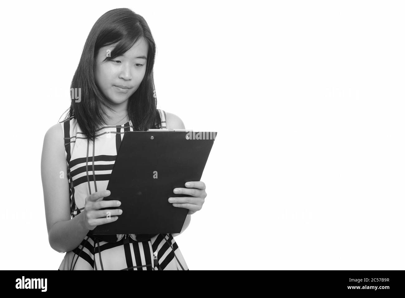 Portrait von glücklich junge schöne asiatische Geschäftsfrau Lesung auf Zwischenablage Stockfoto