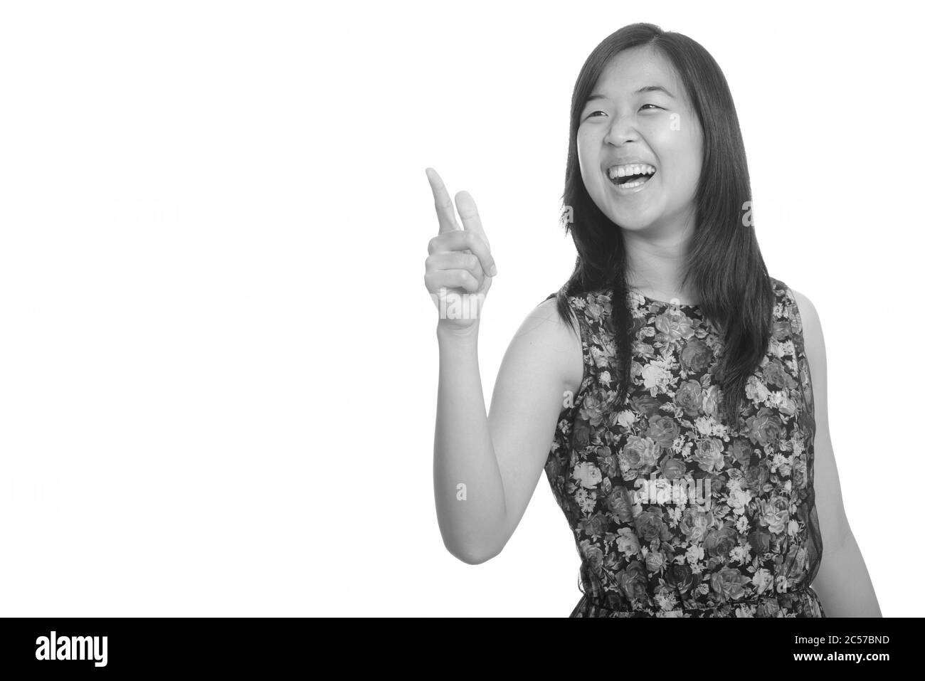 Junge asiatische Frau glücklich lachend, während Zeigefinger Stockfoto