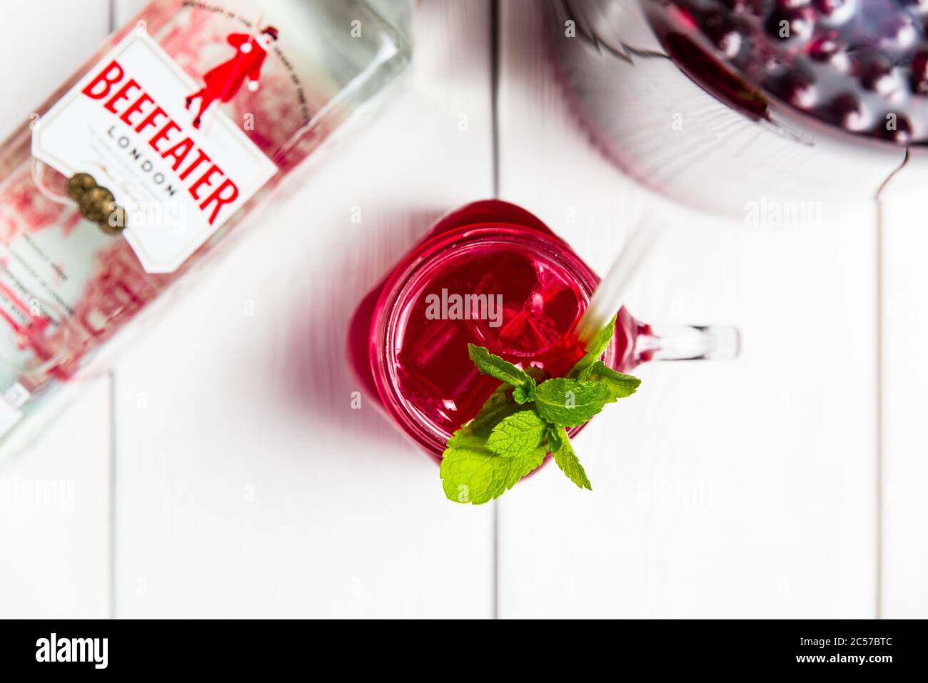 Belarus, Minsk, 24. Mai 2018. Ein erfrischender kalter Kirschalkoholcocktail im Glas mit Beefeater London Dry Gin, Eis und Minze. Stockfoto