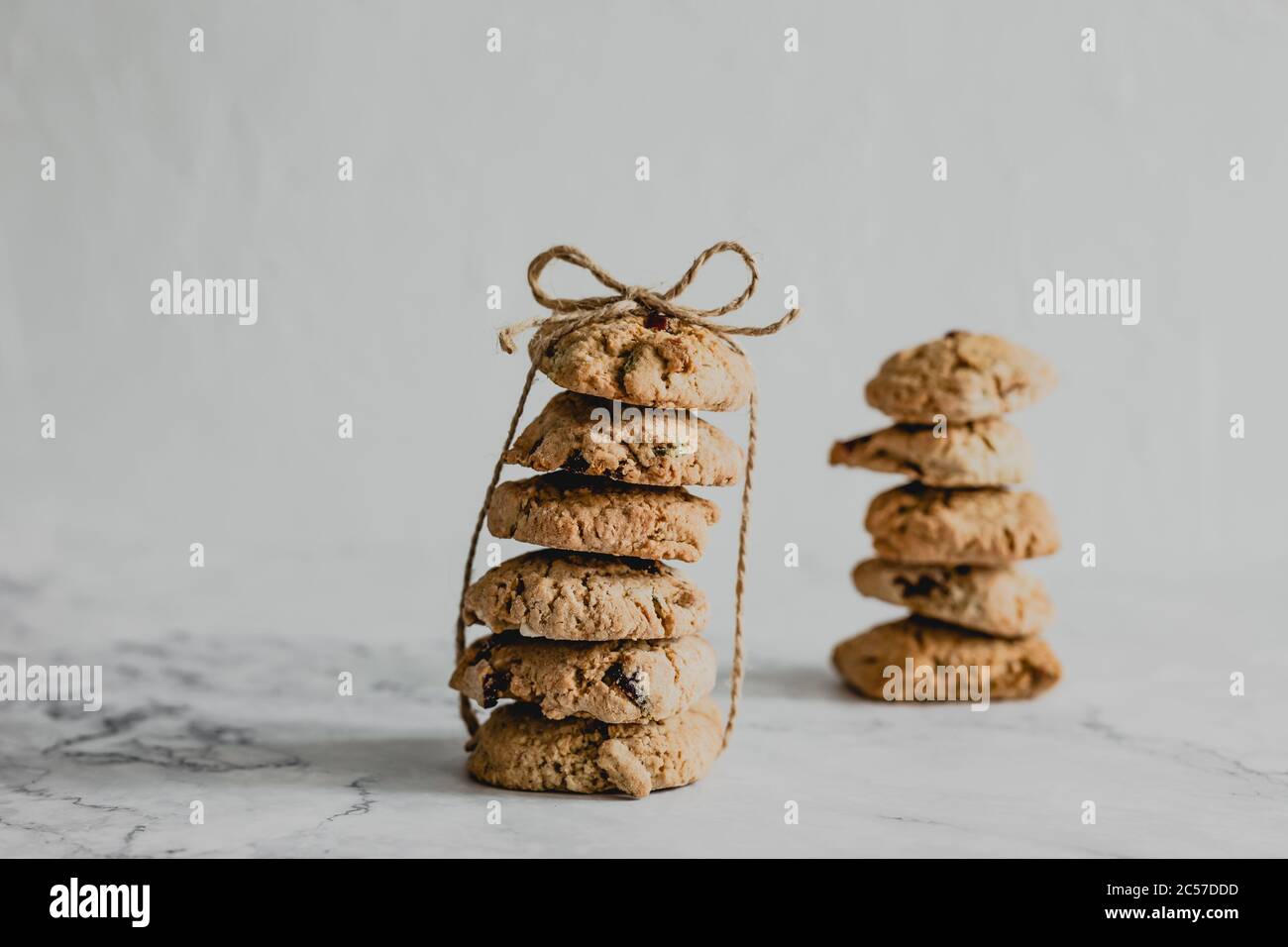 Zwei Stapel Haferflocken Cranberry Cookies mit einem Packfaden gebunden Stockfoto