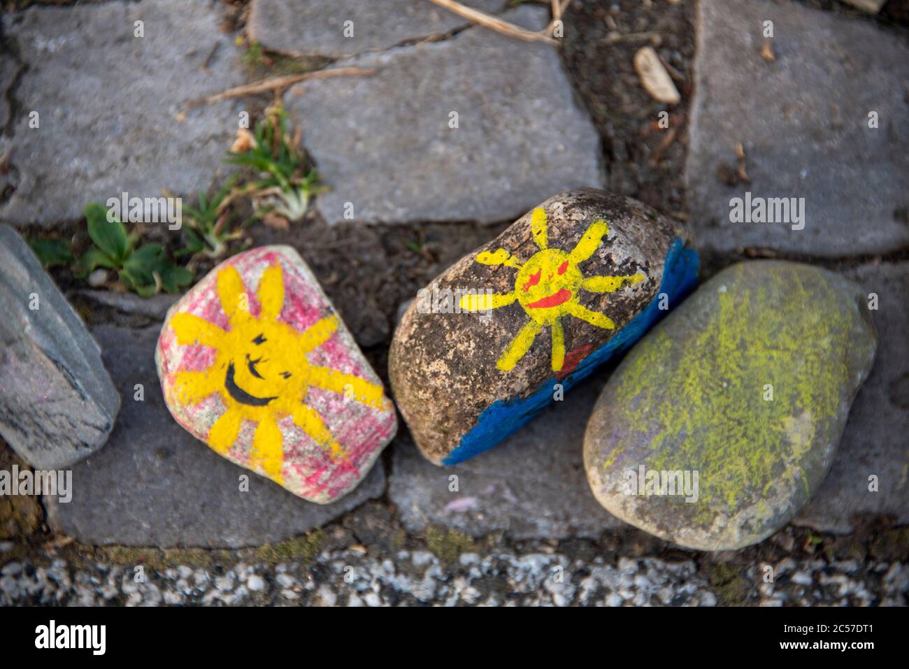 Deutschland, Sachsen-Anhalt, Magdeburg: Vor der Kindertagesstätte Pinocchio sind farbige Steine mit gelben Sonnen. Sie symbolisieren Hoffnung und Freude in diffic Stockfoto