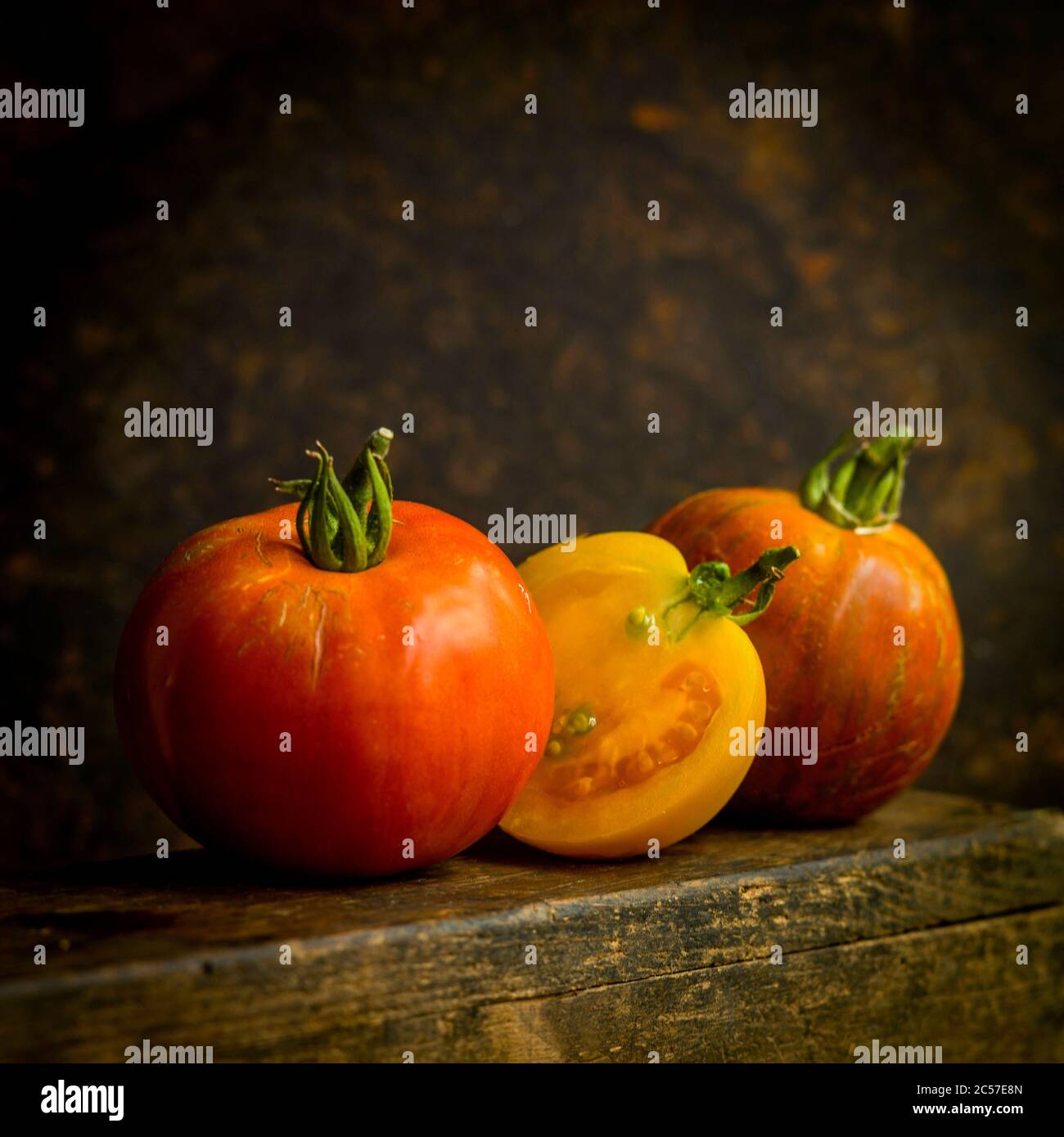 Nahaufnahme einer Vielzahl von Tomaten auf einem braunen Hintergrund Stockfoto