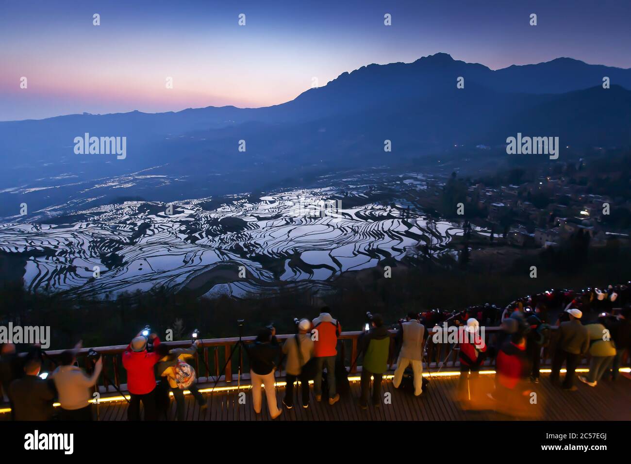 Atemberaubende Aussicht auf Yuanyang Rice Terrassen bei Sonnenaufgang, viele Touristen mit Kameras warten auf Sonnenaufgang auf der Terrasse. Yunnan, China. UNESCO-Welterbe Stockfoto