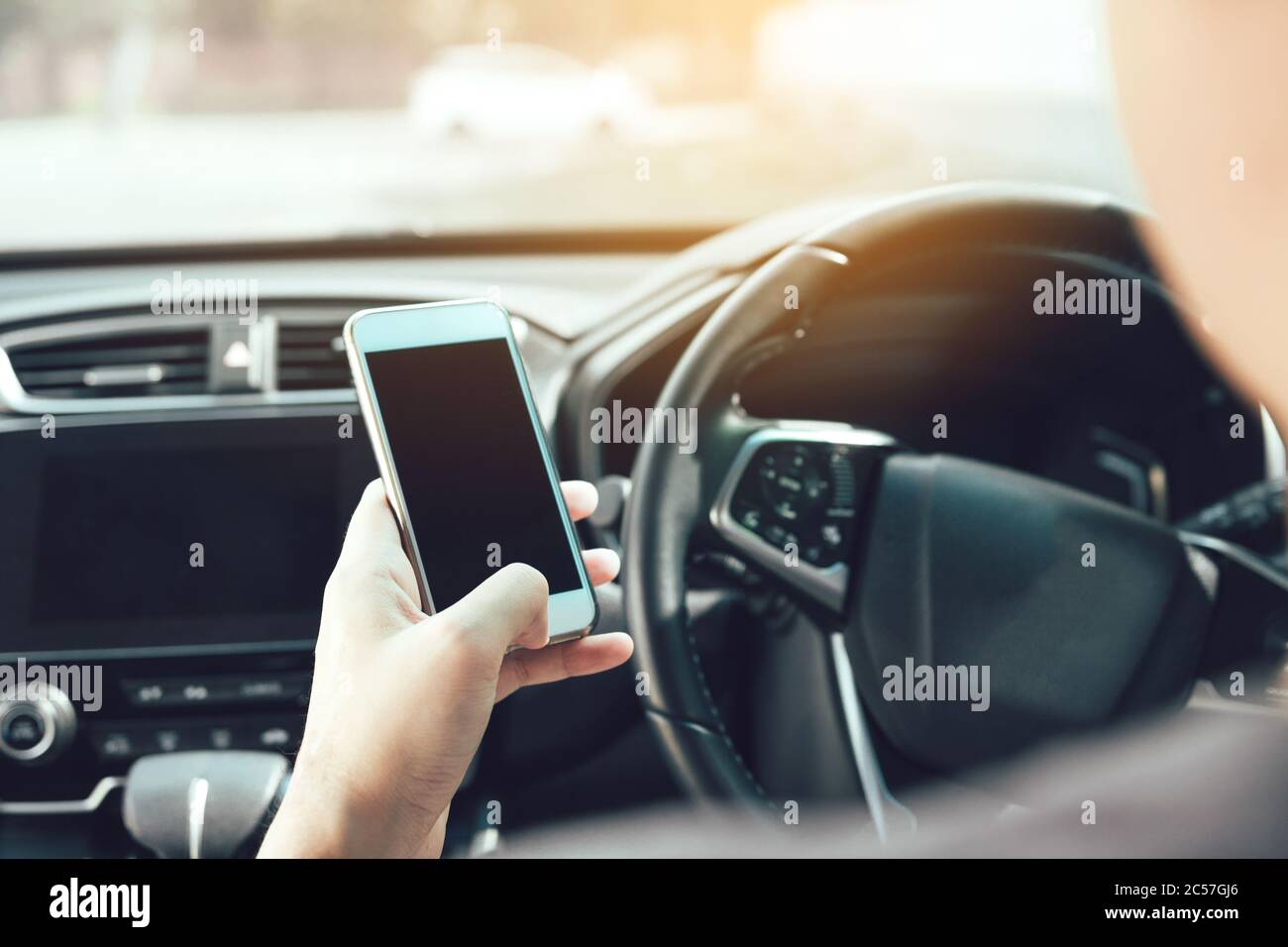 Die Mann Hand ist mit dem Telefon während der Fahrt. Stockfoto