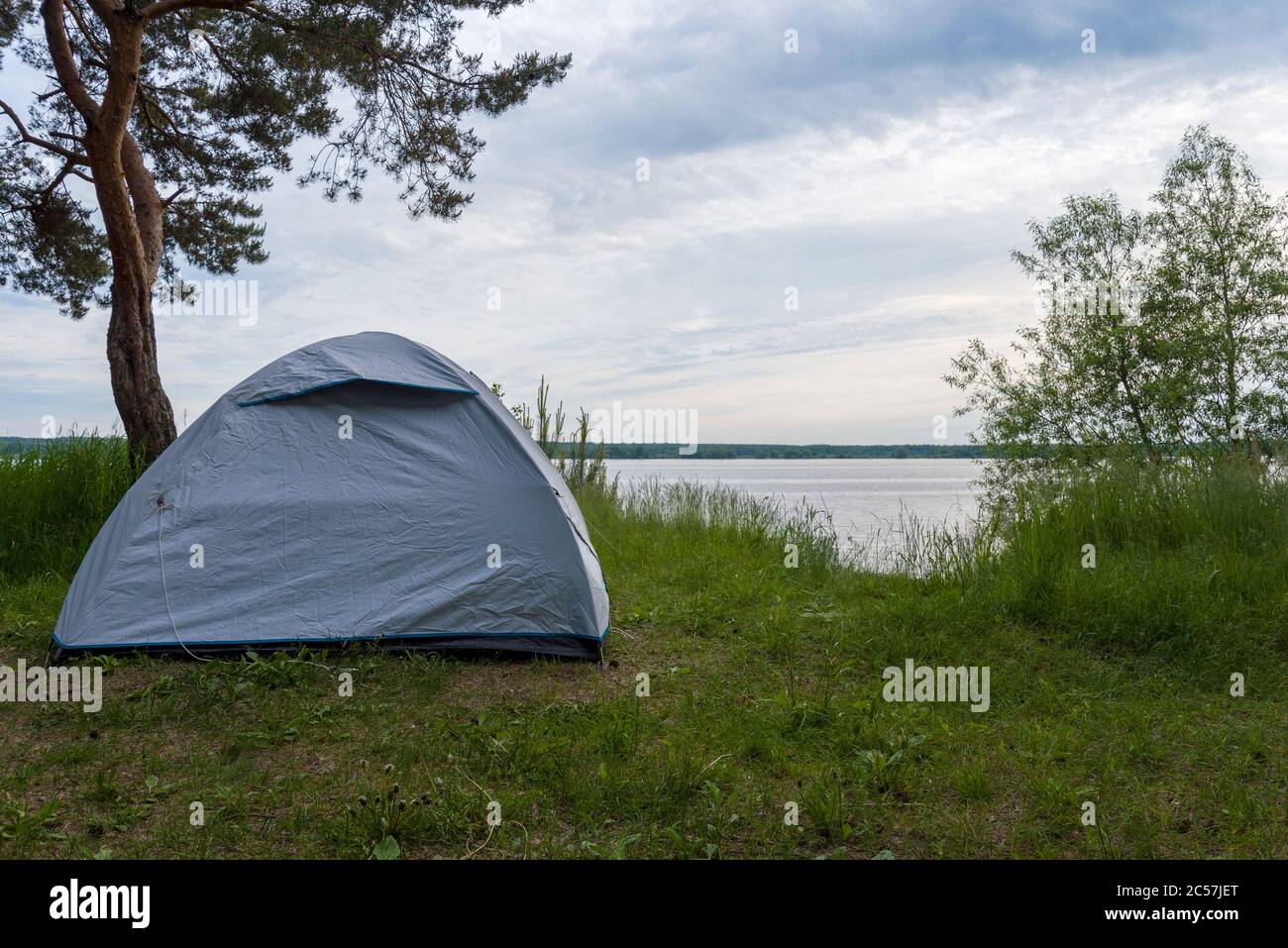 Grünes Zelt am Ufer im Sommer. Konzept von Tourismus und Reisen. Stockfoto