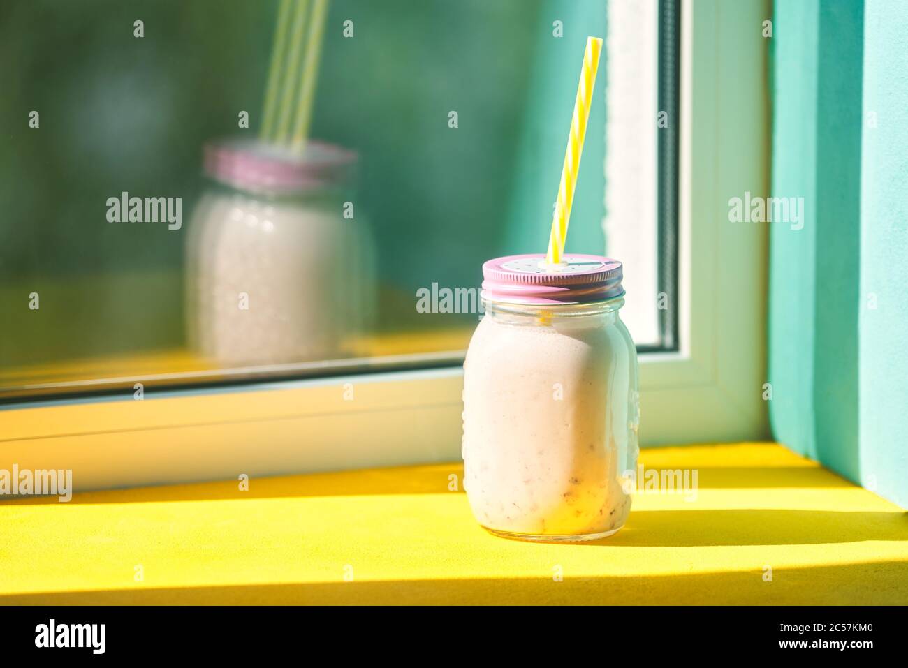 Erdbeer Smoothie Smoothie im Glas mit Strohhalmen auf der Fensterbank. Konzept des Sommers, gute Laune, gesunde Ernährung Stockfoto