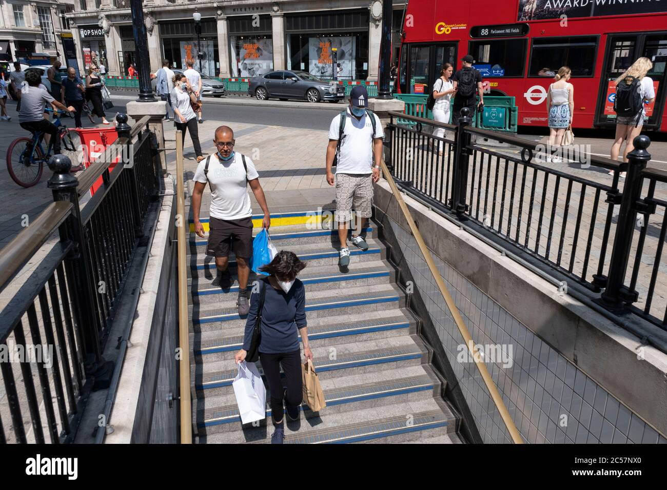 Oxford Circus unter dem Bahnhofseingang während einige nicht unbedingt notwendige Geschäfte wieder geöffnet werden, kehren die Käufer in die Oxford Street zurück, während die verschiedenen Einzelhandelsgeschäfte, die am 26. Juni 2020 in London, England, Großbritannien, geöffnet sind, soziale Distanzierungsmaßnahmen ergreifen. Da die Frist für den Juli näher kommt und die Regierung ihre Sperrregeln weiter lockern wird, bleibt das West End ruhig, abgesehen von diesem beliebten Einkaufsviertel, das selbst weit weniger Menschen auf seinen Gehwegen hat als normal. Stockfoto