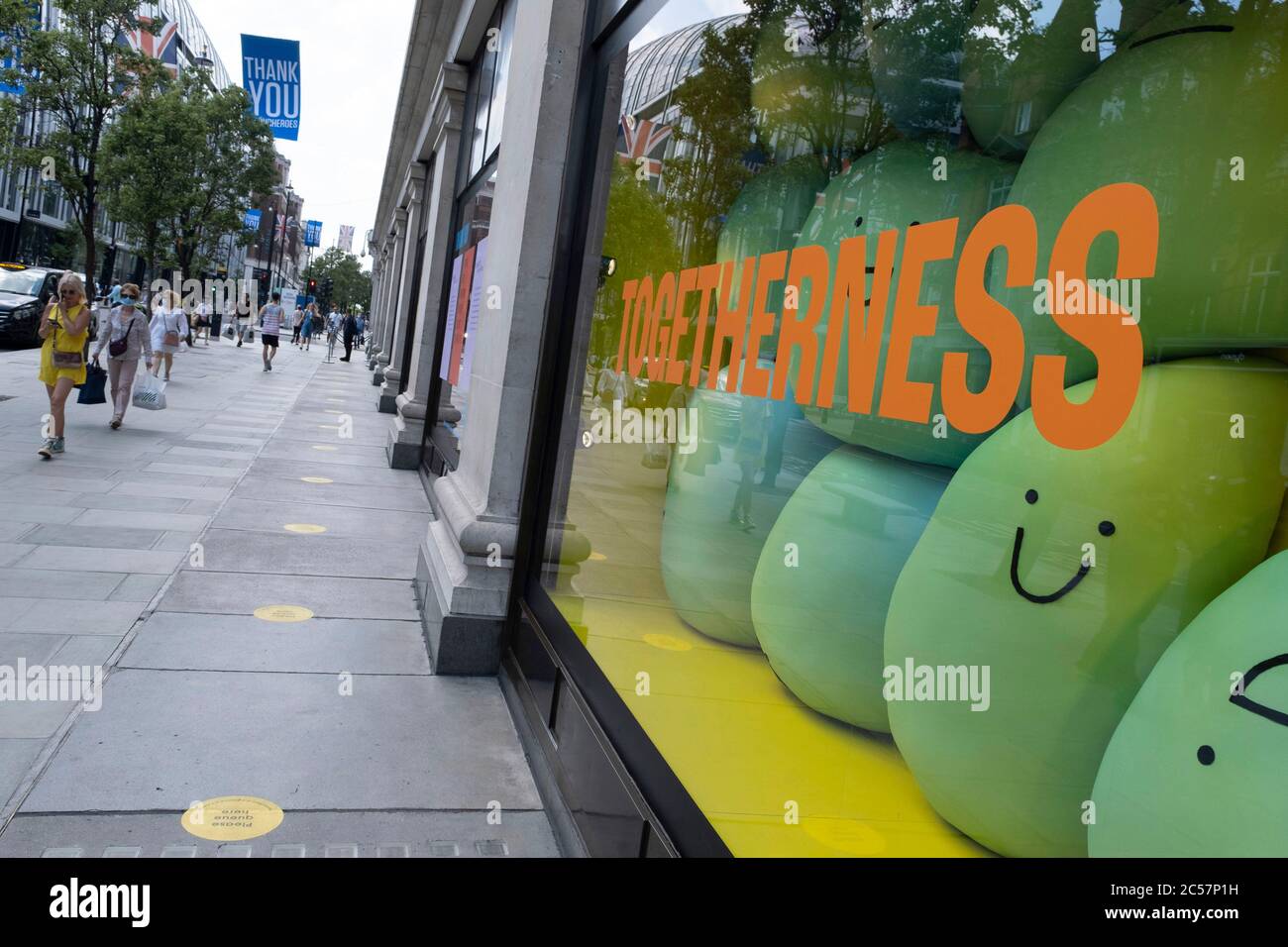 Das Zeichen der Zweisamkeit im Fenster von Selfridges während einige nicht-wesentliche Geschäfte wieder geöffnet werden, kehren die Käufer in die Oxford Street zurück, während die verschiedenen Einzelhandelsgeschäfte, die am 26. Juni 2020 in London, England, Großbritannien, geöffnet sind, soziale Distanzierungsmaßnahmen ergreifen. Da die Frist für den Juli näher kommt und die Regierung ihre Sperrregeln weiter lockern wird, bleibt das West End ruhig, abgesehen von diesem beliebten Einkaufsviertel, das selbst weit weniger Menschen auf seinen Gehwegen hat als normal. Stockfoto