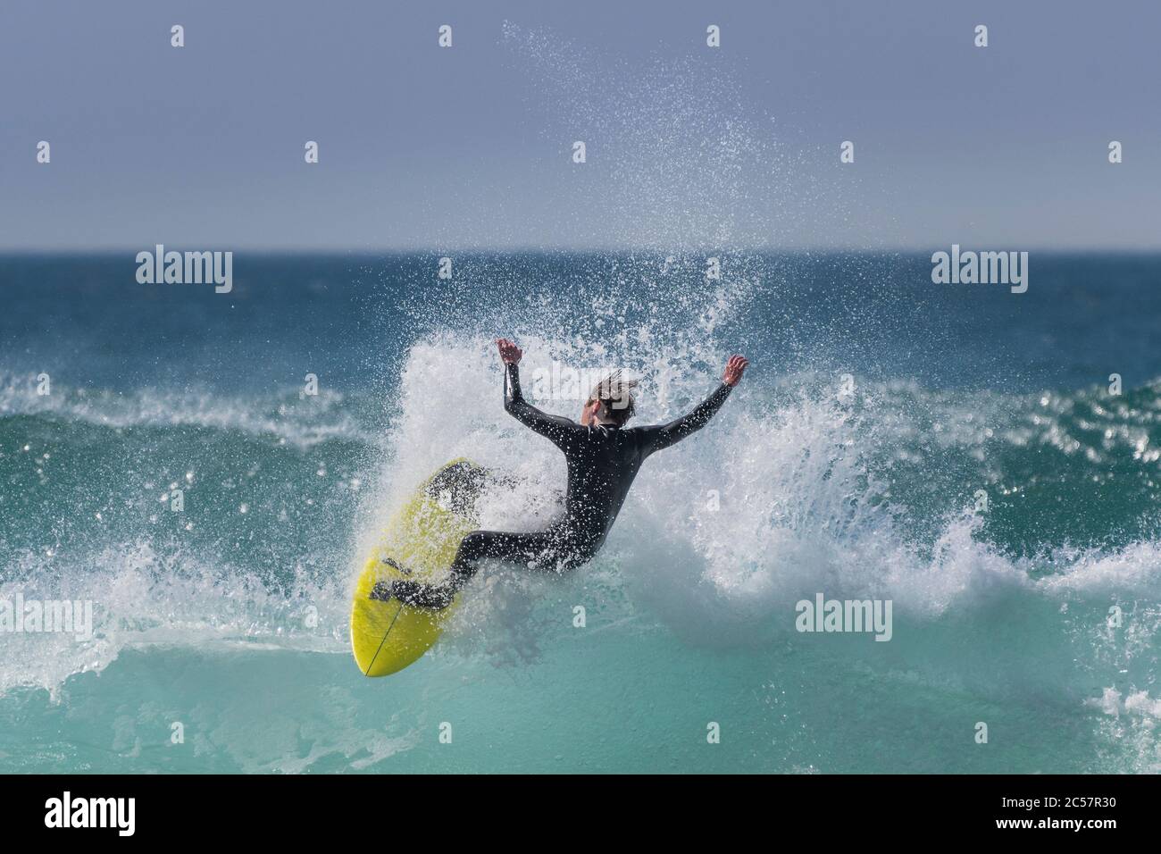 Wilde spektakuläre Action als Surfer reitet eine Welle am Fistral in Newquay in Cornwall. Stockfoto