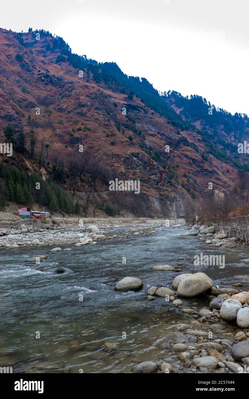 Fließender Fluss mit Felsen im Fluss und mit schönen Bergen im Hintergrund Stockfoto