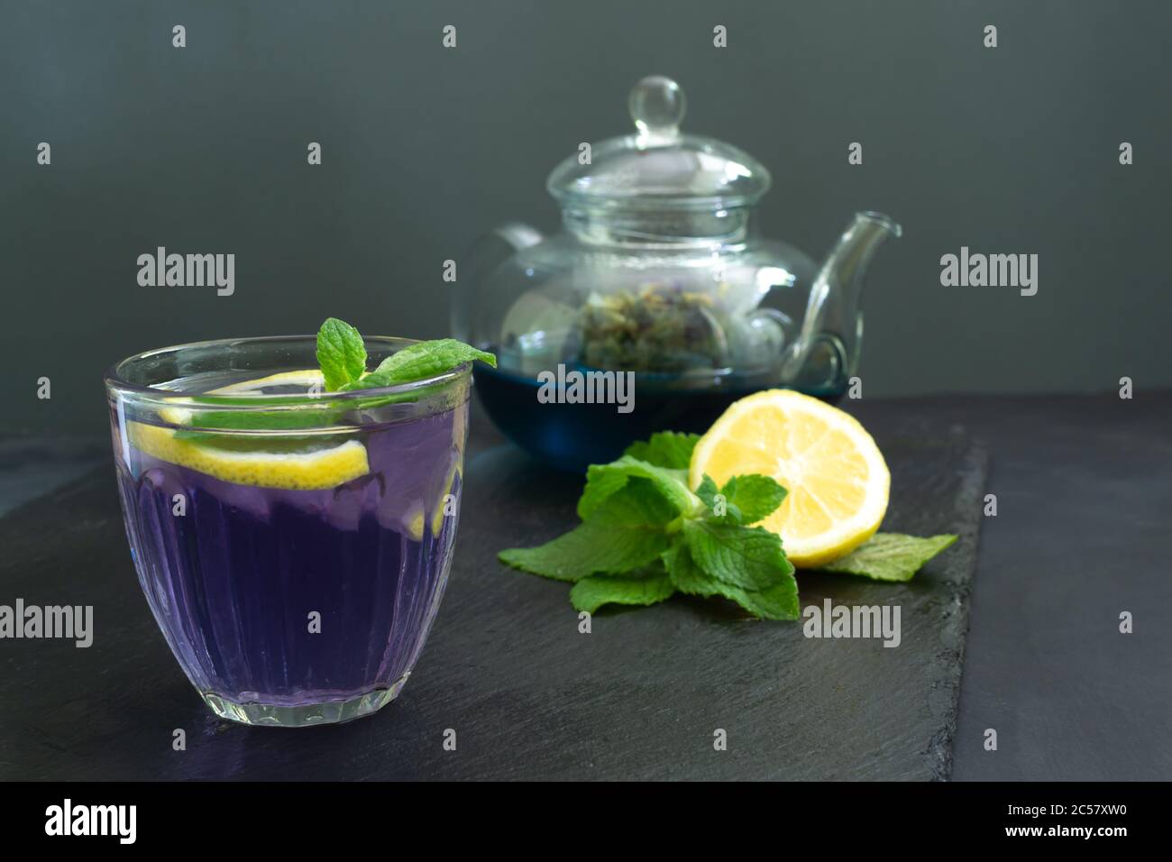 Kalter blauer Thai Anchan Tee in einer Glasschale mit Eis und einer transparenten Teekanne. Speicherplatz kopieren. Stockfoto