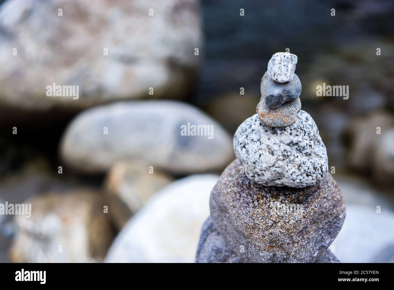 Rock Balancing: Stein Stacking Kunst mit fließenden Fluss im Hintergrund Stockfoto