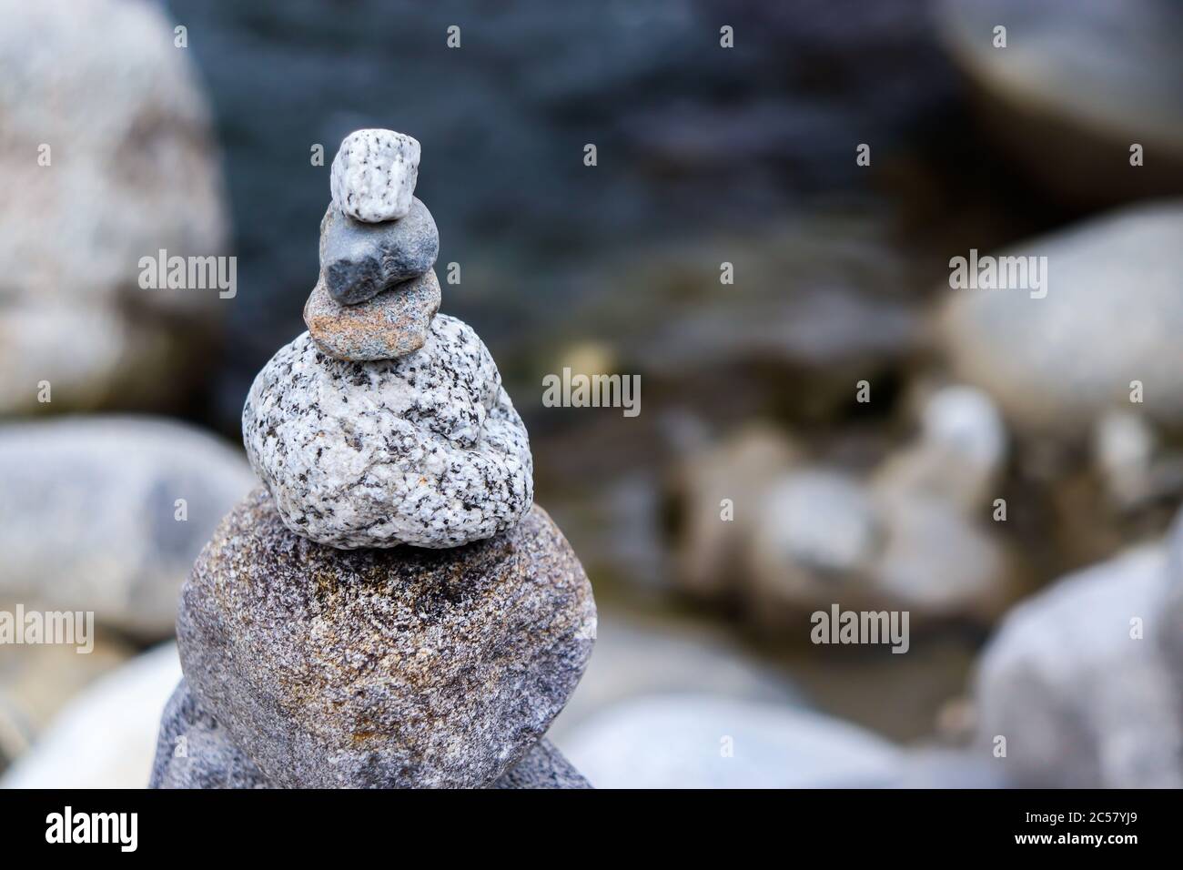 Rock Balancing: Stein Stacking Kunst mit fließenden Fluss im Hintergrund Stockfoto