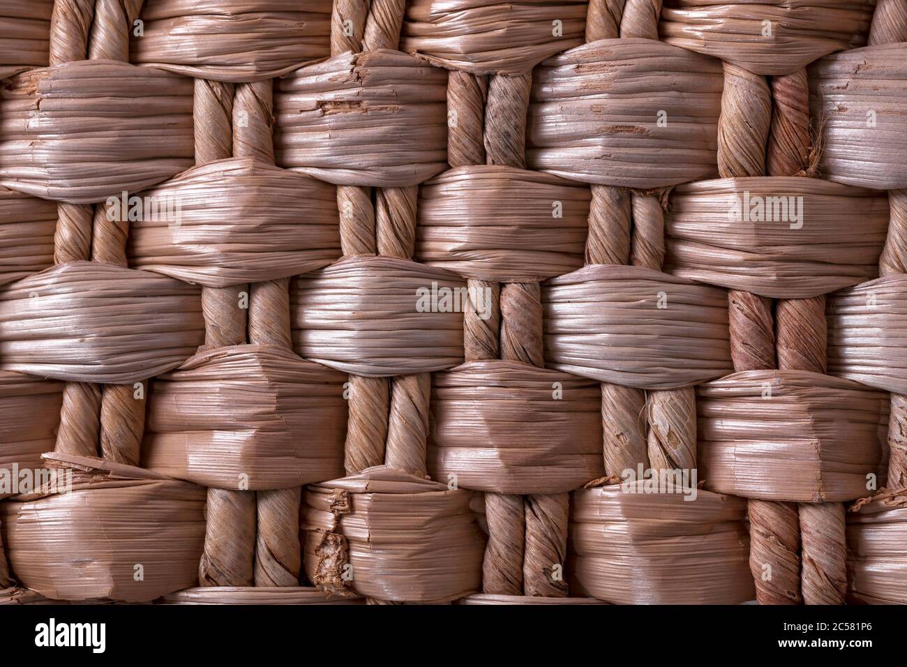 Weben aus getrockneten Pflanzenfasern. Schöne Textur. Korbflechten. Schönes, gewebtes Muster aus Pflanzenfasern. Stockfoto