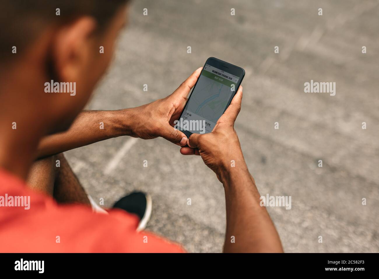 Nahaufnahme eines Mannes, der die Zusammenfassung seines Laufs auf Handy-App überprüft. Läufer mit einer Fitness-App auf seinem Smartphone. Stockfoto