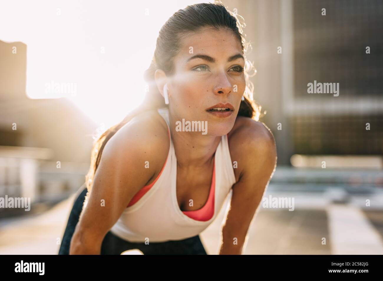 Die Läuferin stand und verschnaufte sich nach einer Laufstunde in der Stadt den Atem. Sportlerin, die nach einem Lauf Pause einnahm. Stockfoto
