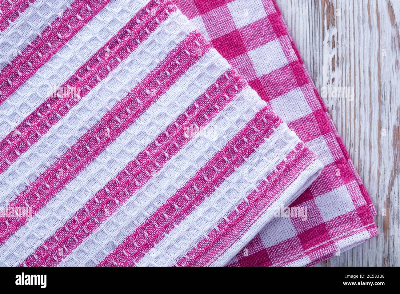 Ein Stapel Handtücher und Servietten liegen auf dem Tisch. Küchentücher reinigen, Handtücher auf dem Tisch liegen. Ordnung in der Küche. Bunte Servietten, Handtücher. Stockfoto