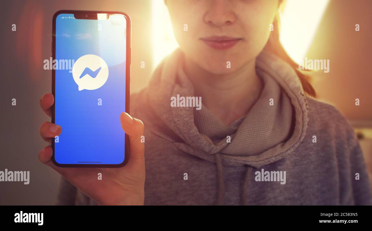KIEW, UKRAINE-JANUAR, 2020: Facebook Messenger auf Handy-Bildschirm. Junge Mädchen zeigt Smartphone-Bildschirm mit Facebook Messenger auf sie, während Sie auf die Kamera. Konzentrieren Sie sich auf Smartphone. Stockfoto