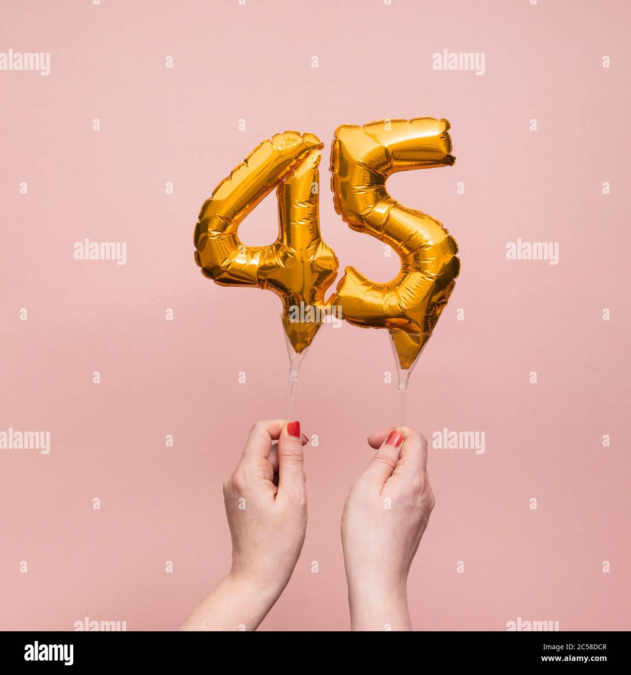 Weibliche Hand hält eine Zahl 45 Geburtstag Feier Gold Ballon Stockfoto