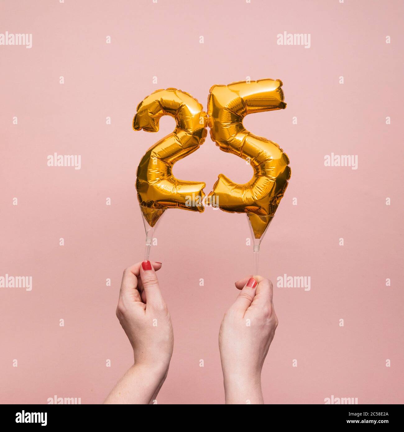 Weibliche Hand hält eine Zahl 25 Geburtstag Feier Gold Ballon Stockfoto