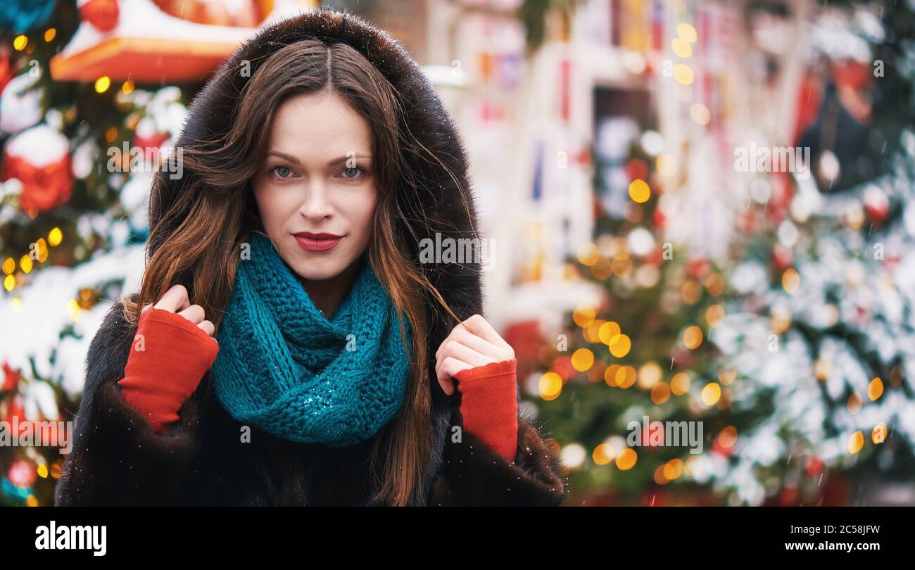 Hübsche Frau trägt Pelzmantel. Weihnachten auf der City Street Stockfoto