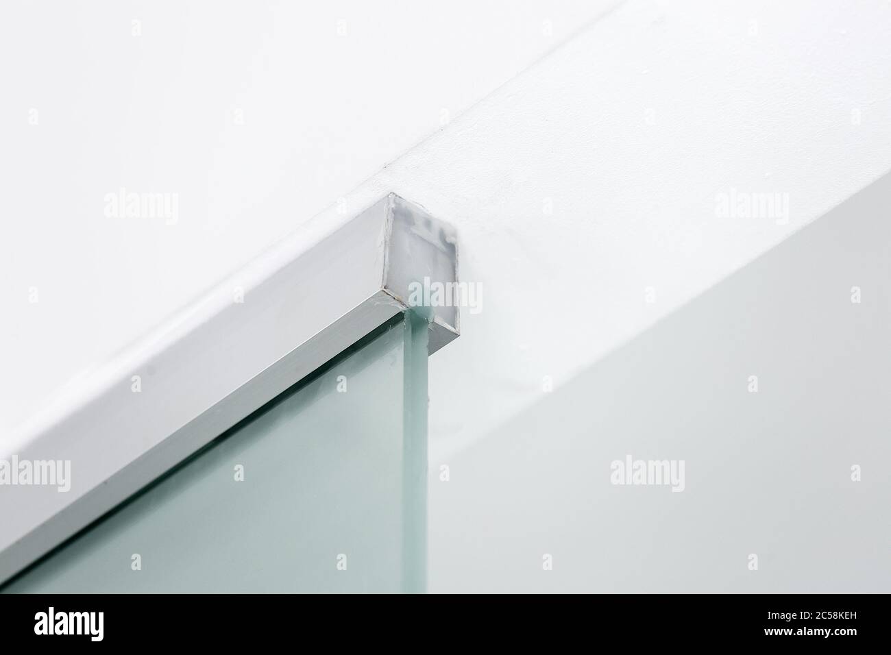 Metallbefestigung an der Decke einer Glaswand, Nahaufnahme von inneren Details. Stockfoto