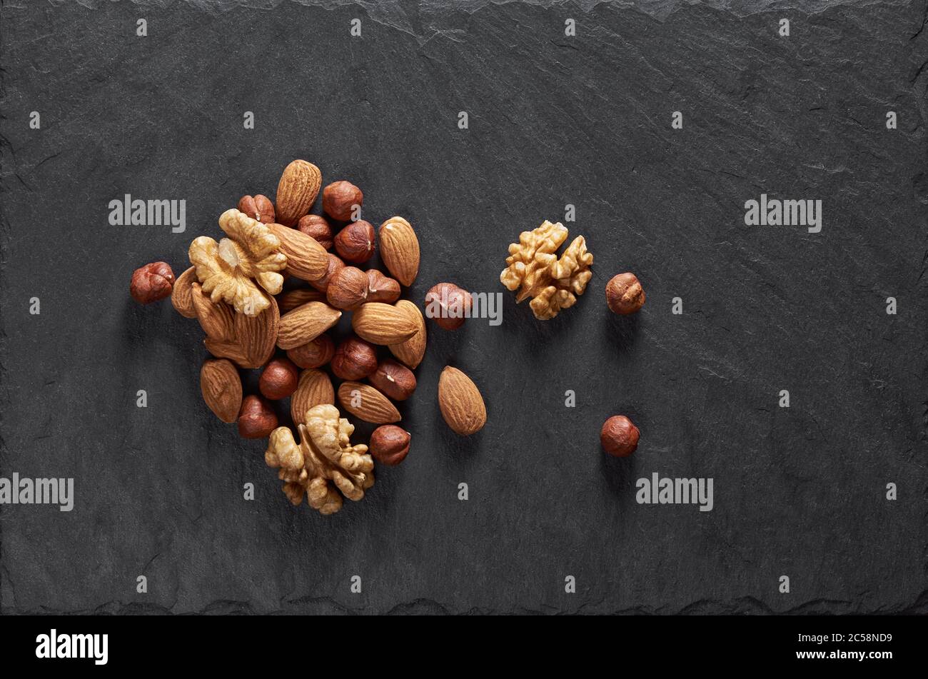 Nüsse mischen sich auf einem Steintisch. Draufsicht Stockfoto