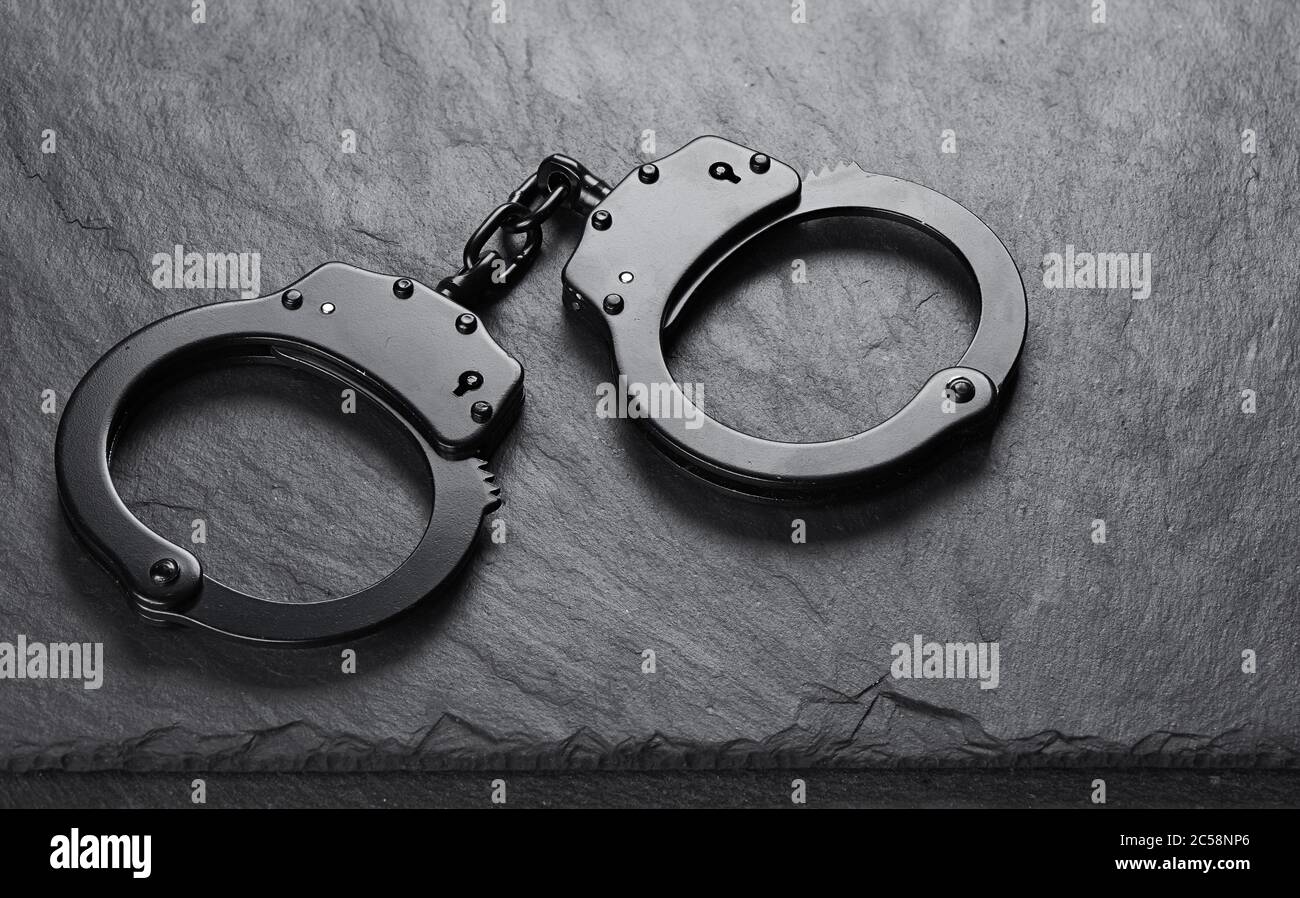 Alte schwarze Handschellen auf Steingrund Stockfotografie - Alamy