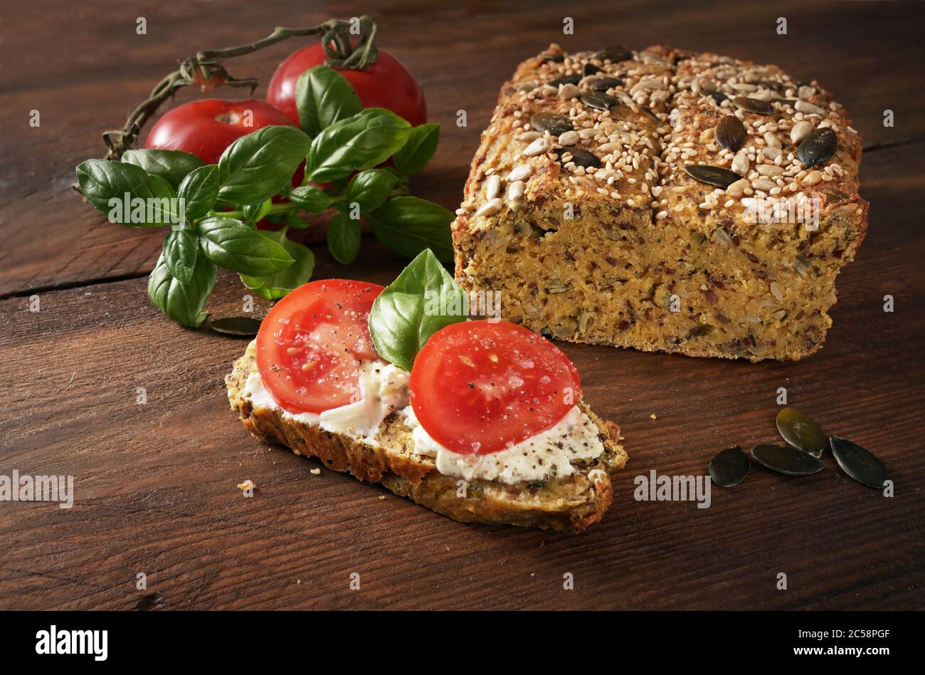 Gesundes Sandwich, hausgemachtes Proteinbrot mit Frischkäse, Tomaten und Basilikum auf einem dunklen rustikalen Holztisch, Schlankheitskur mit Low Carb oder ketogener Diät Stockfoto