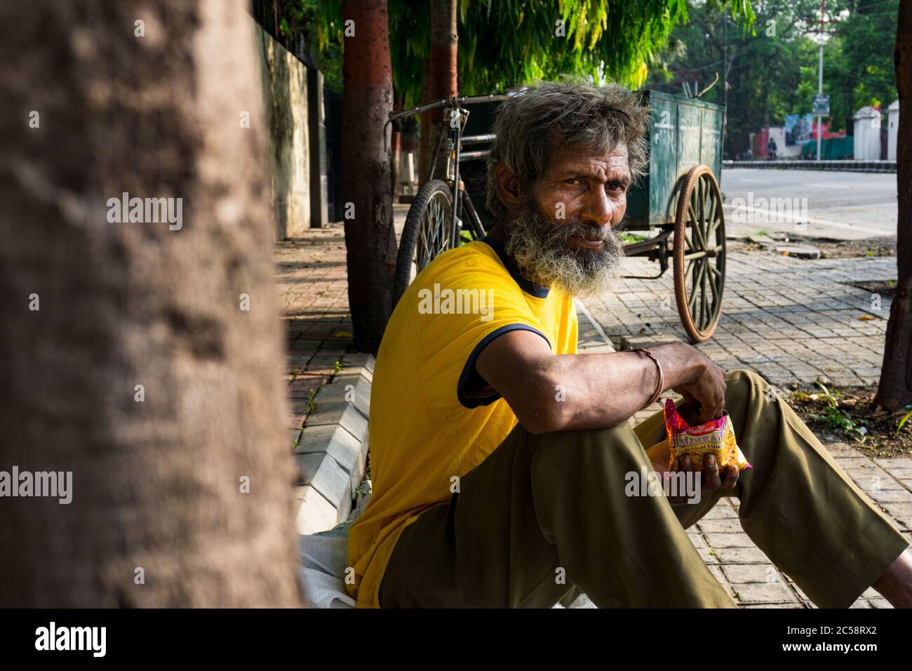 Editorial dated:16 june 2020 Location : dehradun India. Ein Hausloser auf der Straße, der einen Snack isst. Stockfoto