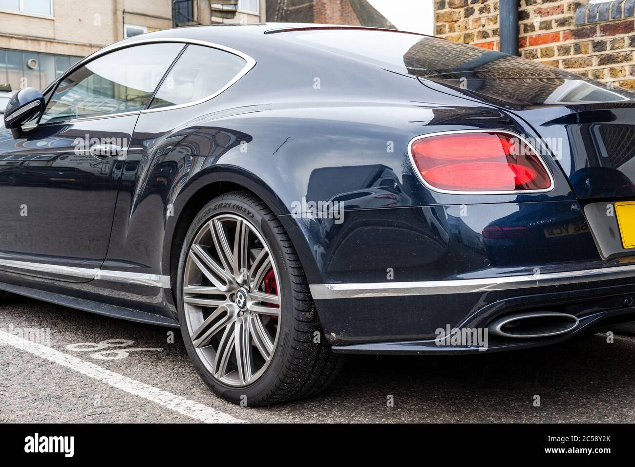 Flacher Fokus, isolierte Ansicht eines berühmten, britischen Luxusauto-Logos auf dem Kofferraum eines Sportwagens. In einem privaten Parkplatz. Stockfoto