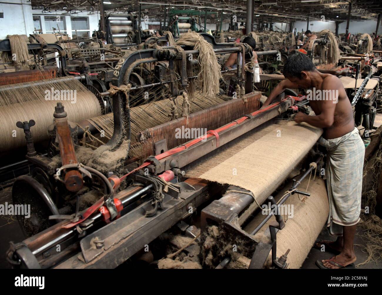 DHAKA, BANGLADESCH - 01JULY 2020: Arbeiter arbeiten damit, Jutesäcke in der Juteverarbeitungsfabrik in Narayanganj in der Nähe von Dhaka zu machen. Jute Industry in Bangladesch ist eine Industrie, die historisch und kulturell wichtig ist und einst die größte Branche der Region war. Stockfoto