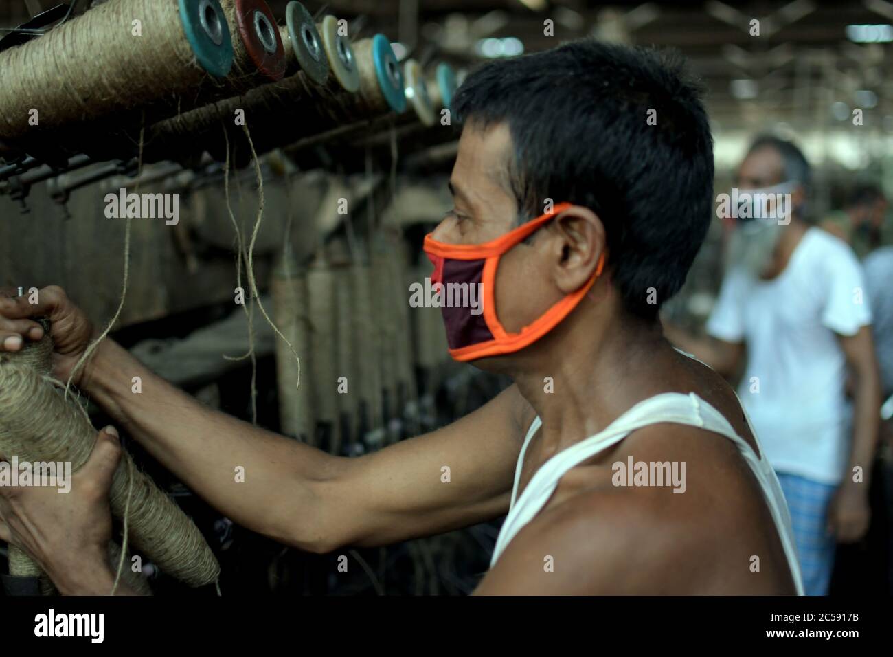 DHAKA, BANGLADESCH - 01JULY 2020: Arbeiter arbeiten damit, Jutesäcke in der Juteverarbeitungsfabrik in Narayanganj in der Nähe von Dhaka zu machen. Jute Industry in Bangladesch ist eine Industrie, die historisch und kulturell wichtig ist und einst die größte Branche der Region war. Stockfoto