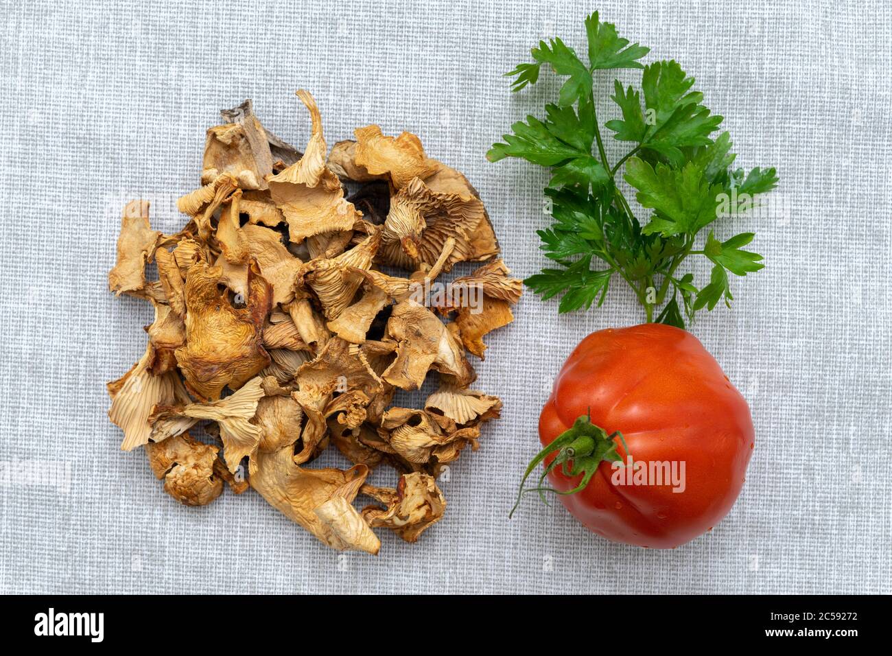 Pilze, Tomaten und Grüns auf einer Serviette aus Leinwand. Kulinarisches Layout Stockfoto