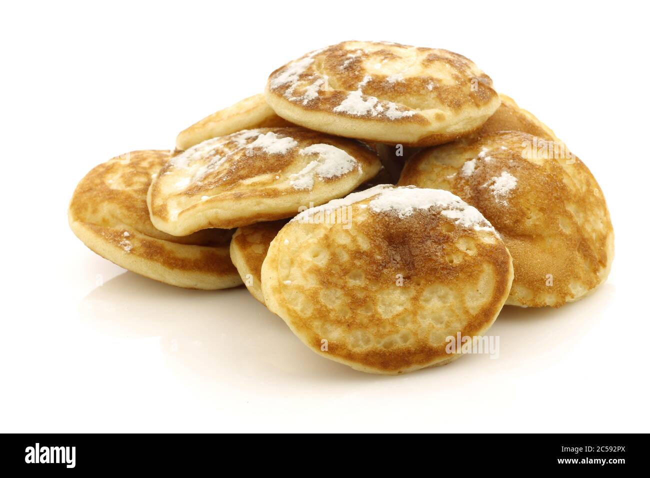 Frisch gebackene traditionelle holländische Mini-Pfannkuchen genannt "poffertjes" mit Puderzucker auf weißem Hintergrund Stockfoto