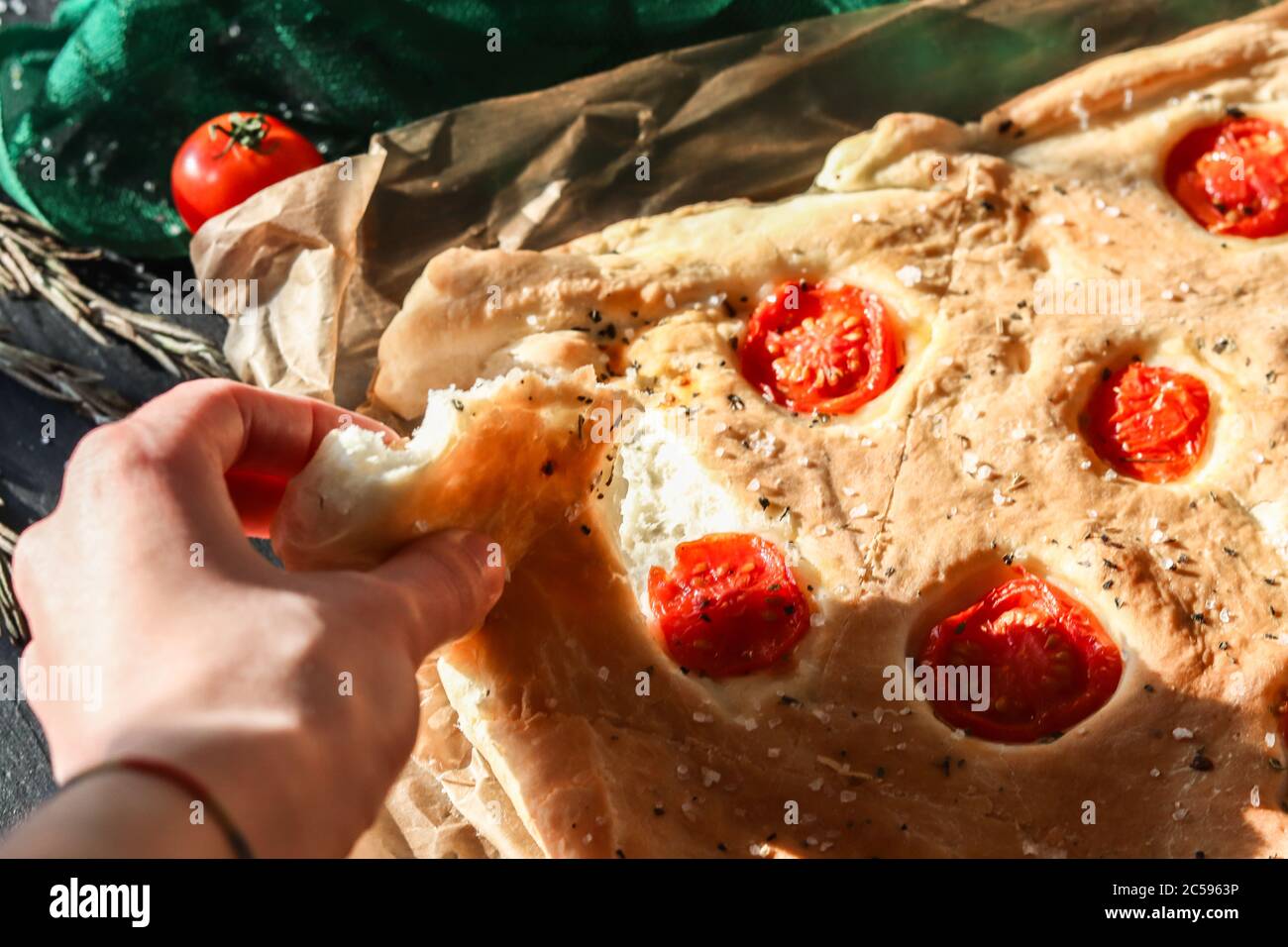 Junge Frau Hand reißen ein Stück frisch gebacken italienisches hausgemachtes Focaccia-Brot Stockfoto