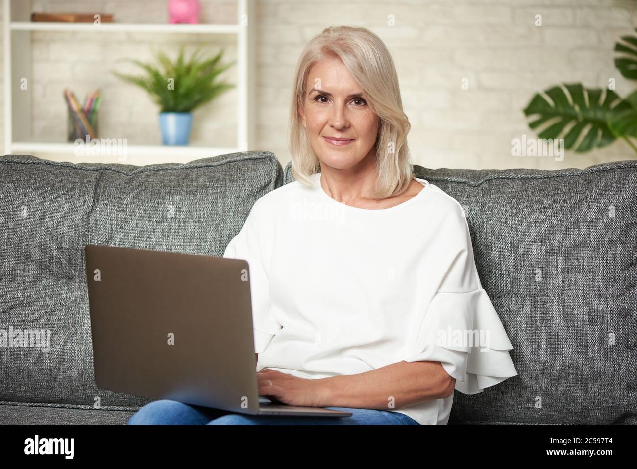 Ältere Frau zu Hause Surfen auf Laptop-Computer Stockfoto