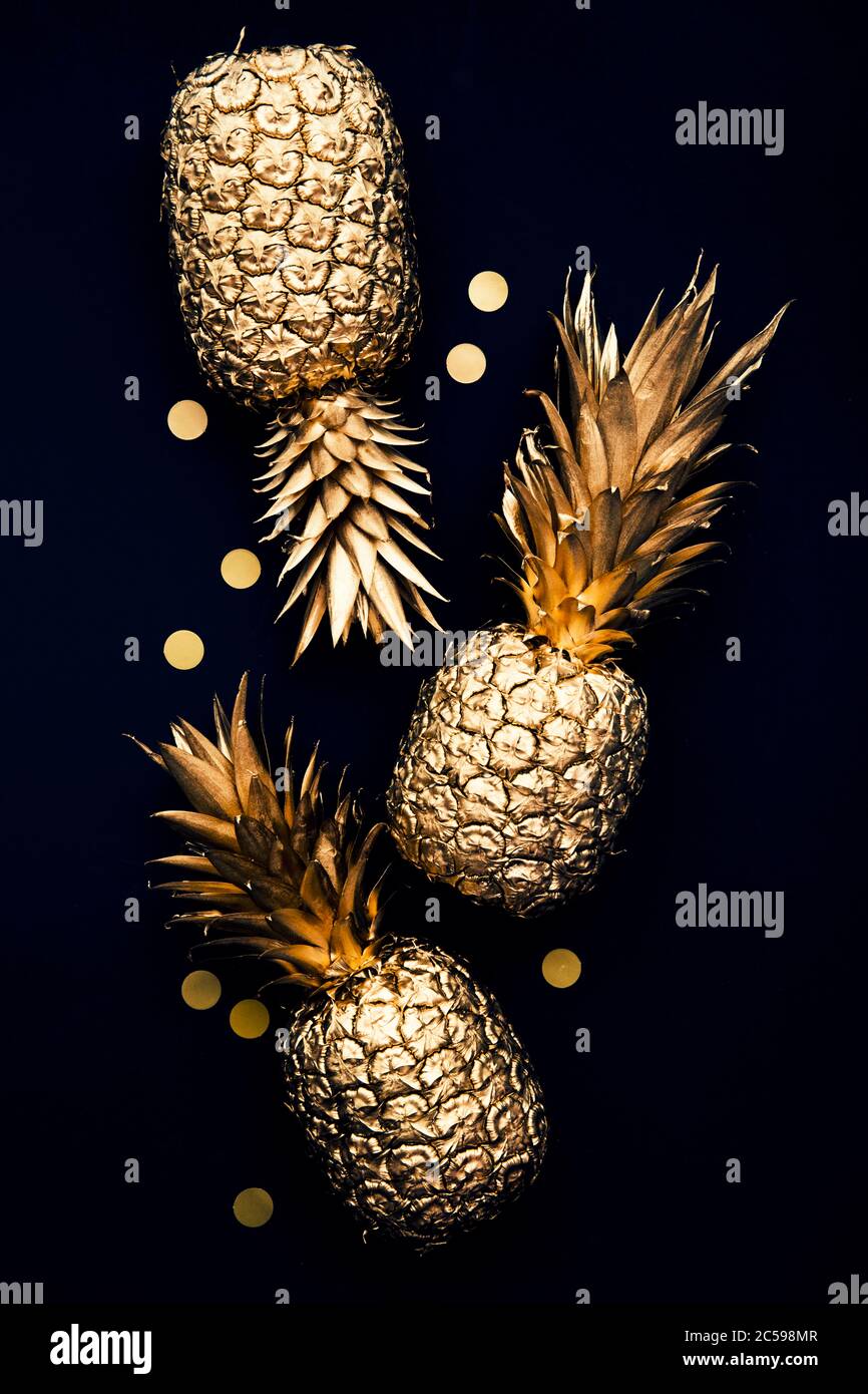 Flach legen tropische Gold Ananas und Konfetti auf einem dunklen Hintergrund Stockfoto