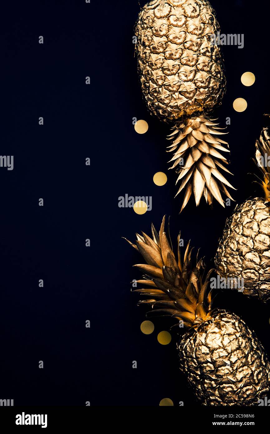 Flach legen tropische Gold Ananas und Konfetti auf einem dunklen Hintergrund Stockfoto