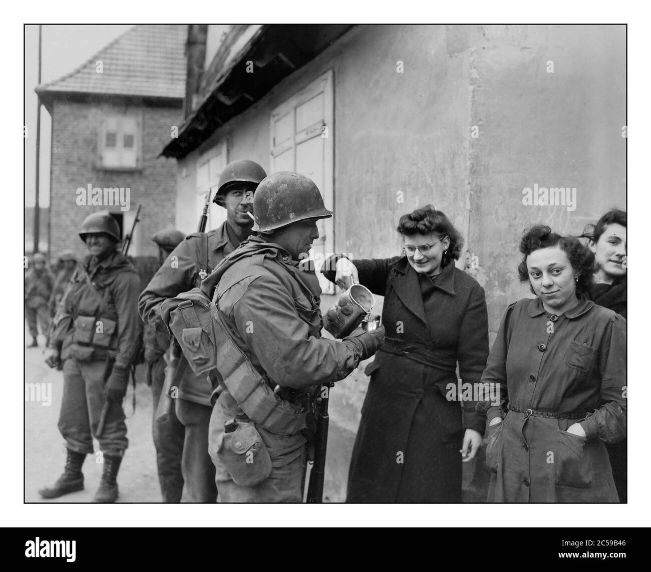 2. Weltkrieg 1945 ELSASS Frankreich amerikanische Soldaten der 79. Infanteriedivision erhalten Wein von französischen Zivilisten während einer Lull in den Kämpfen um Drusenheim, Frankreich am 6. Januar 1945. Im Februar 1945 wehrten die alliierten Truppen die deutsche Offensive erfolgreich ab, sicherten Drusenheim und trieben die Front näher an den Rhein. Die Befreiung Drusenheims war Teil der größeren Bemühungen, die in der Rheinüberquerung und der späteren Niederlage Deutschlands im Mai 1945 gipfelten. Zweiter Weltkrieg ELSASS Stockfoto