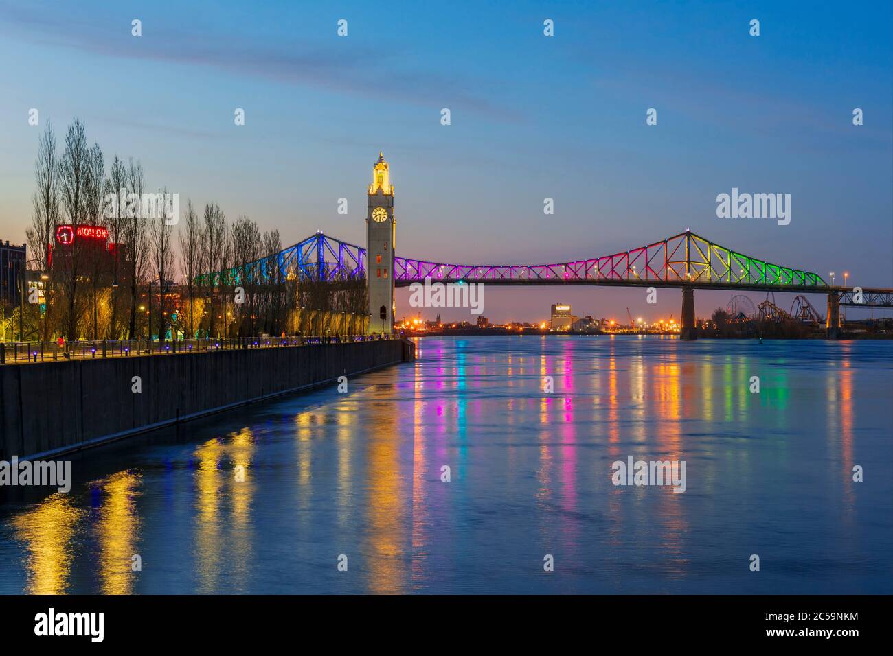 Kanada, Provinz Quebec, Montreal, die Jacques-Cartier-Brücke in den Farben des Regenbogens beleuchtet, Eingrenzungsperiode von COVID-19, der St. Lawrence River, der Uhrenturm Stockfoto