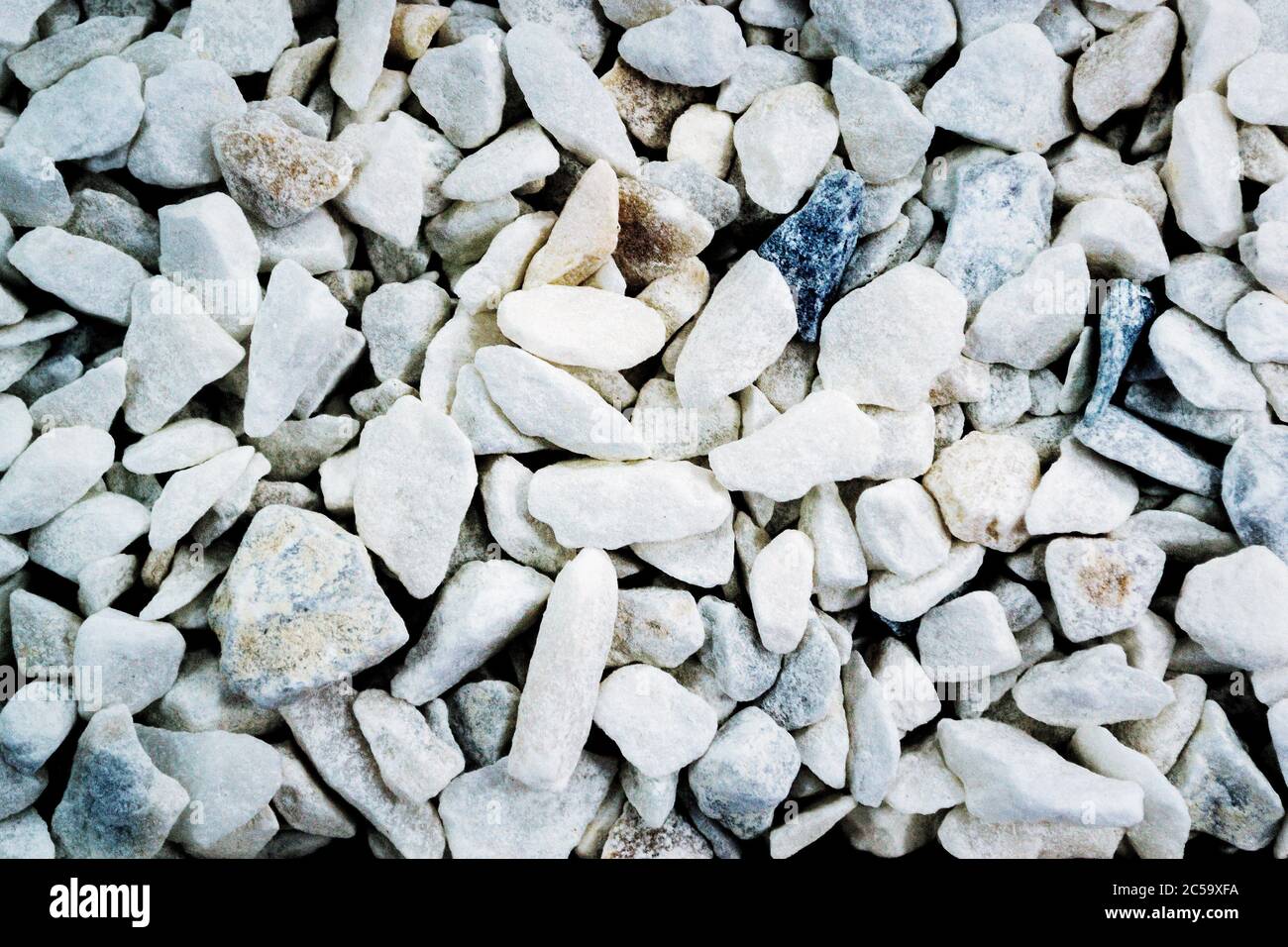 Textur von kleinen hellen dekorativen Steinen im Innenraum Stockfoto