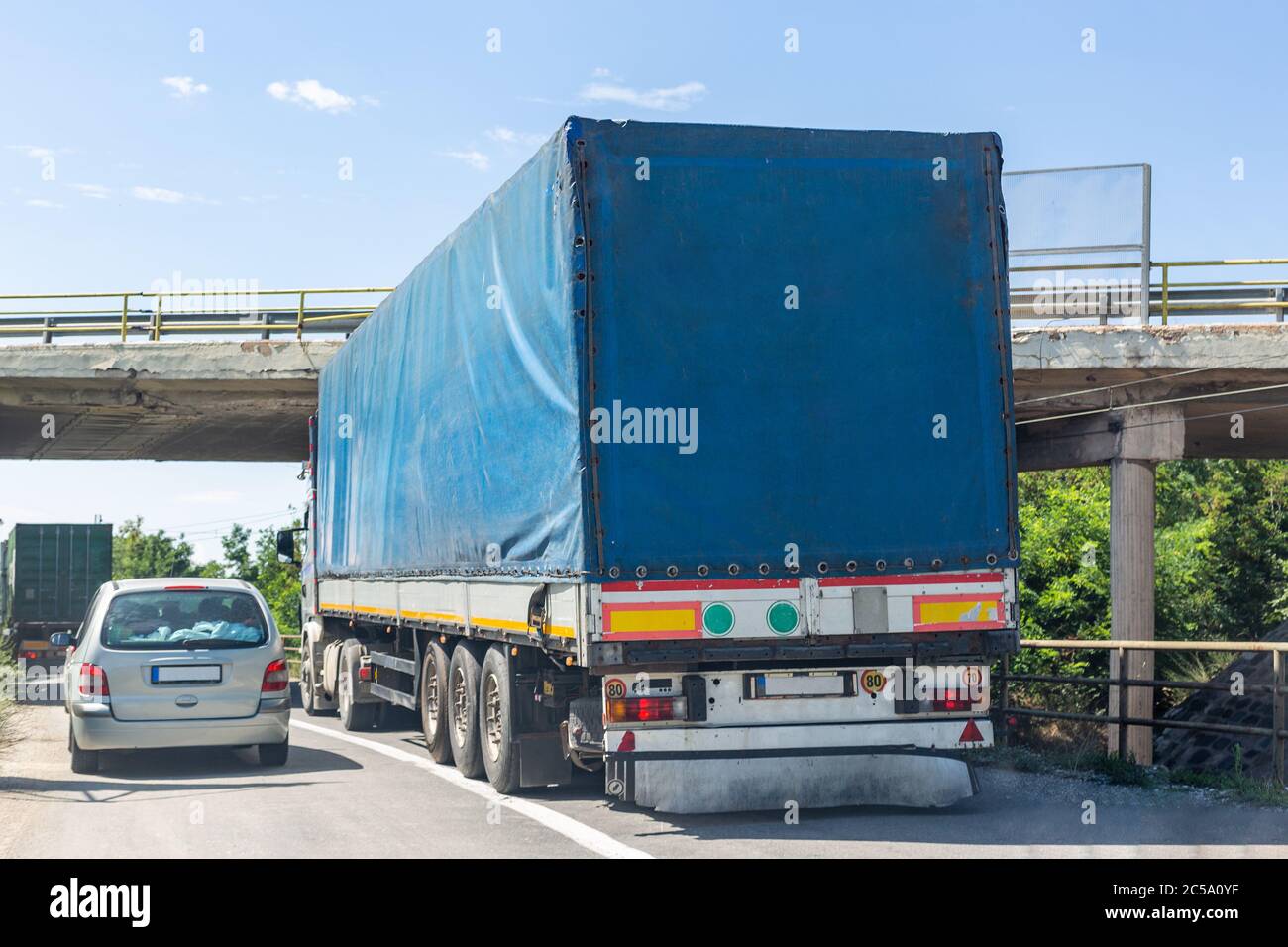 Blauer Weg, der versucht, unter der erhöhten Straße zu passieren. Fahrzeug kollidiert mit der Brücke Stockfoto
