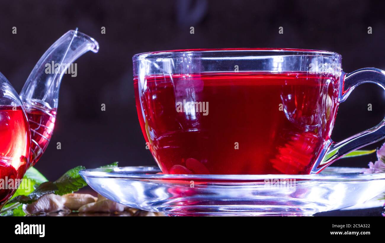 Teestunde: tasse Tee. Kreatives Layout aus einer Tasse Hibiskustee und Teeblätter. Roter Tee, Karkasse, Karkade, Rooibos. Orientalisch, gemütlich, Zeremonie, traditi Stockfoto