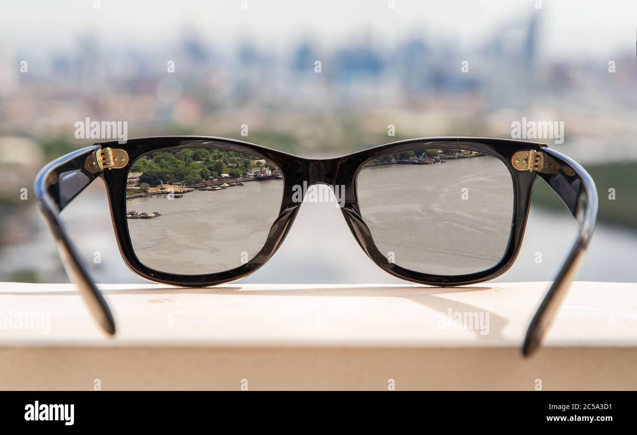 Bangkok, Thailand - Jun 09 2020 : Schwarze Brillen auf einer reflektierenden Oberfläche. Blick durch die Brille, die auf den Chao Phraya River schaut. Stockfoto